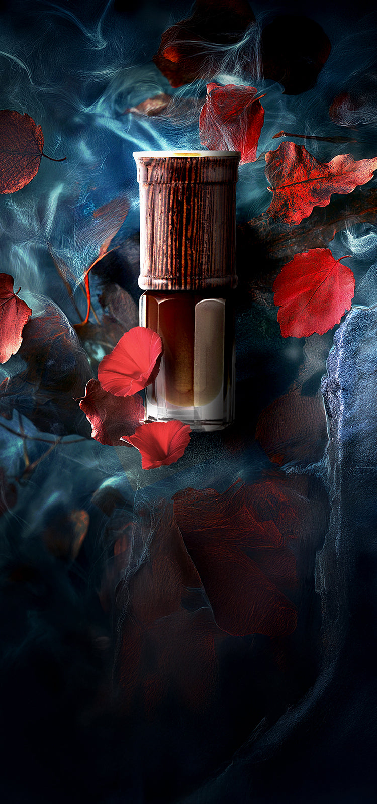 Luxury oud perfume bottle with wooden cap surrounded by red rose petals and blue smoke – SULAYM artisanal fragrance photography.